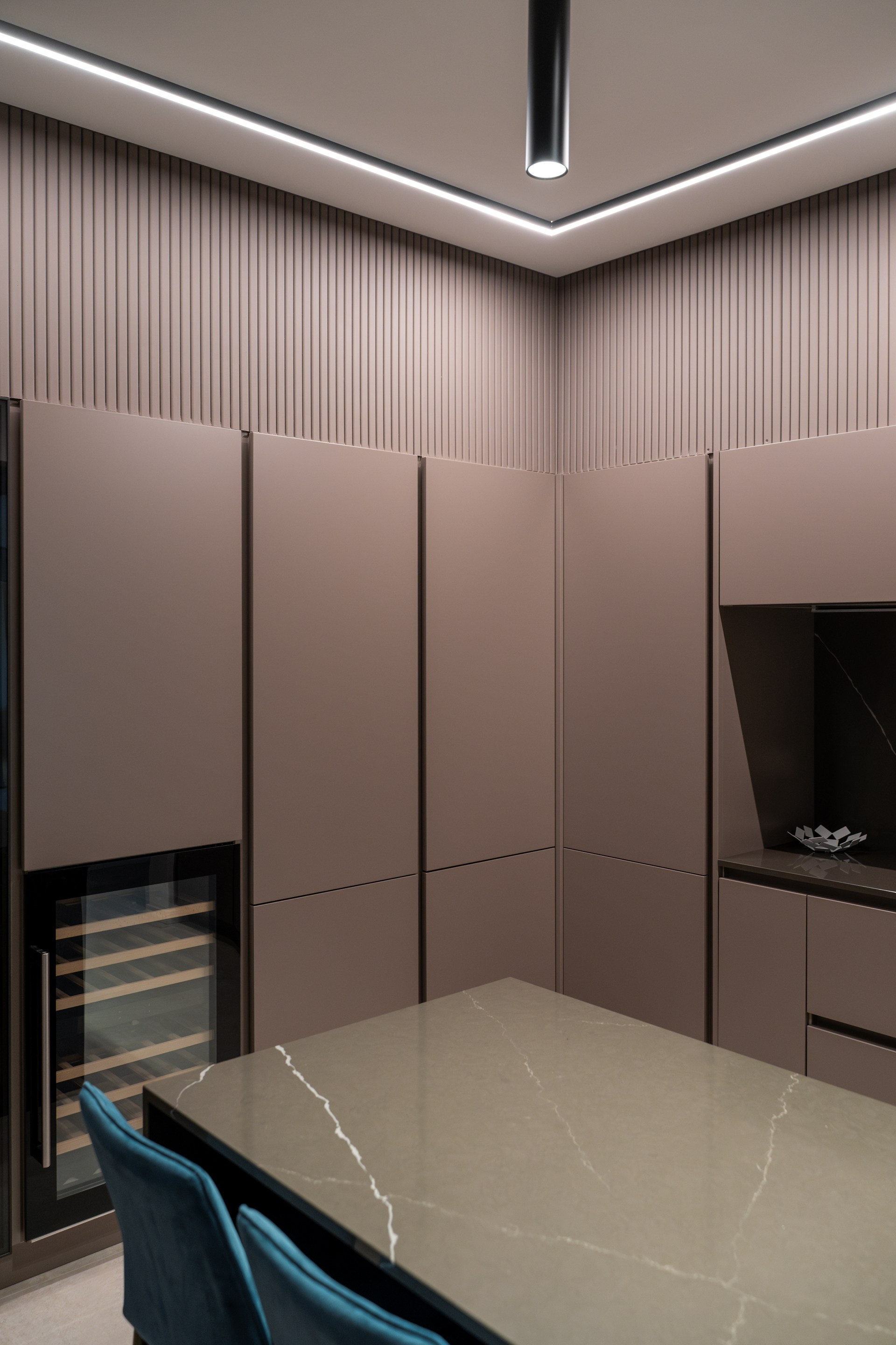 Cornici per illuminazione a soffitto integrate che delineano lo spazio con linee geometriche pulite e un'illuminazione indiretta.